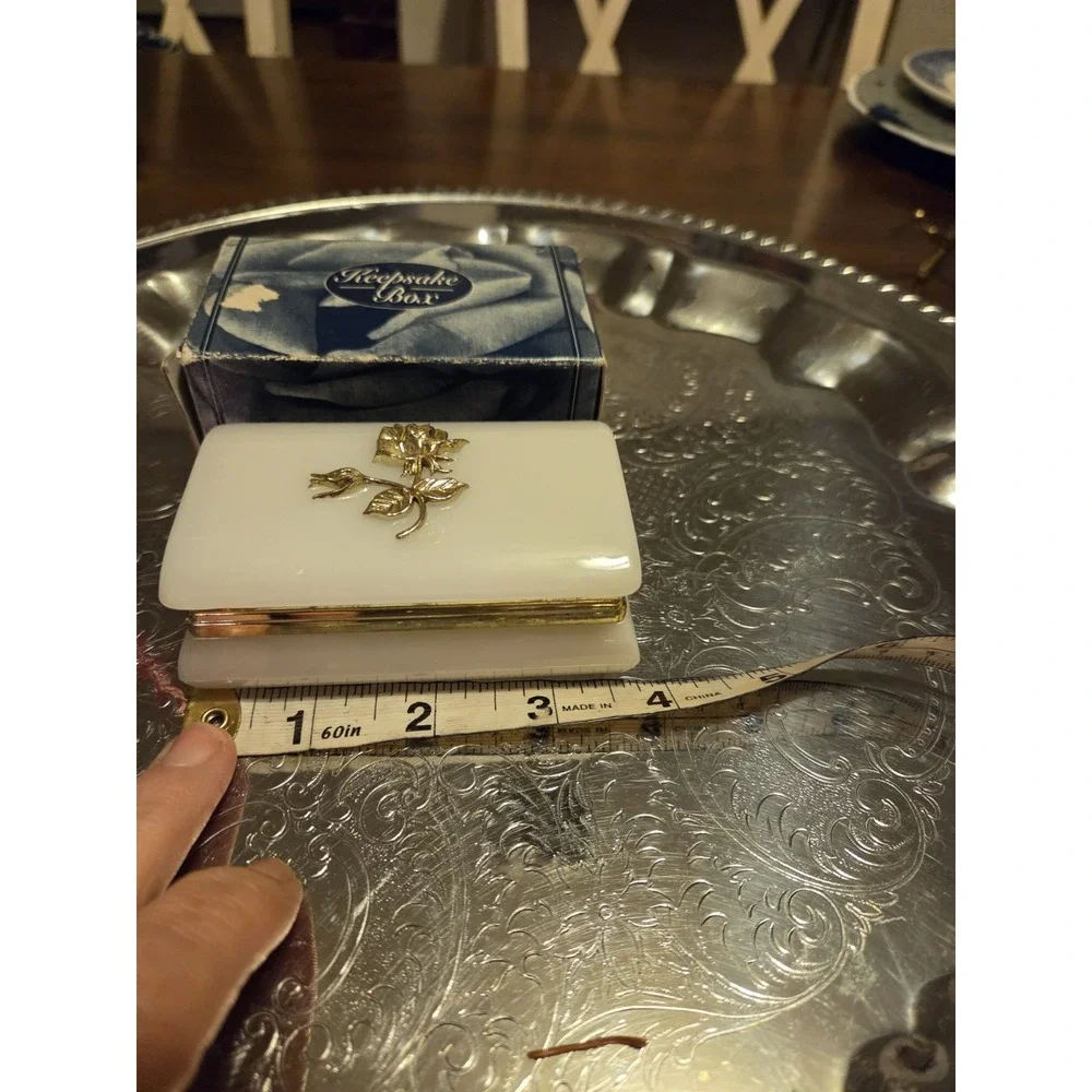 vintage white hinged trinket box features a polished finish with a delicate,...
